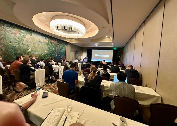 A diverse crowd seated at tables in a conference room