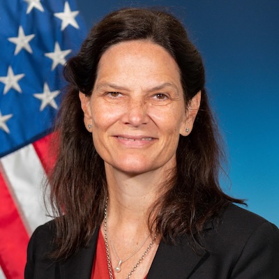 a woman posing for a photo with US flag in the background